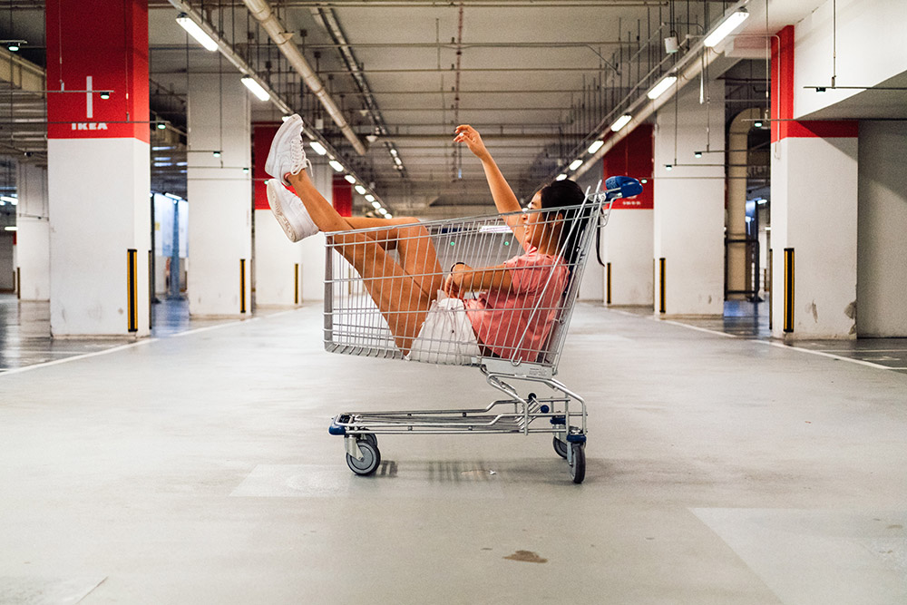 Girl laying on top of shopping cart