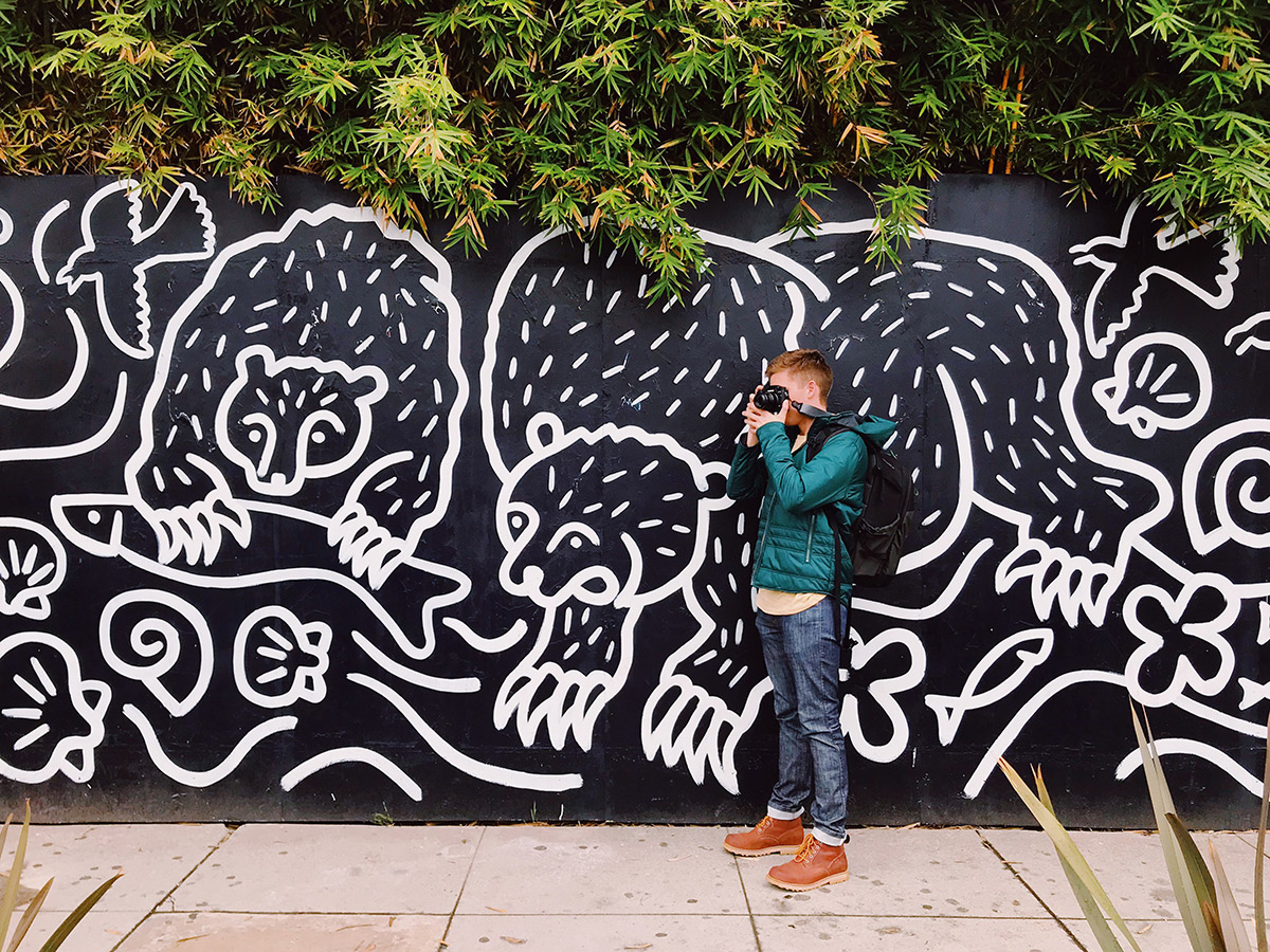 Men photographing near a creative wall with illustrations
