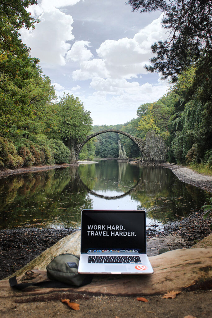 Remote work: laptop near the river "Work hard. Travel Harder."