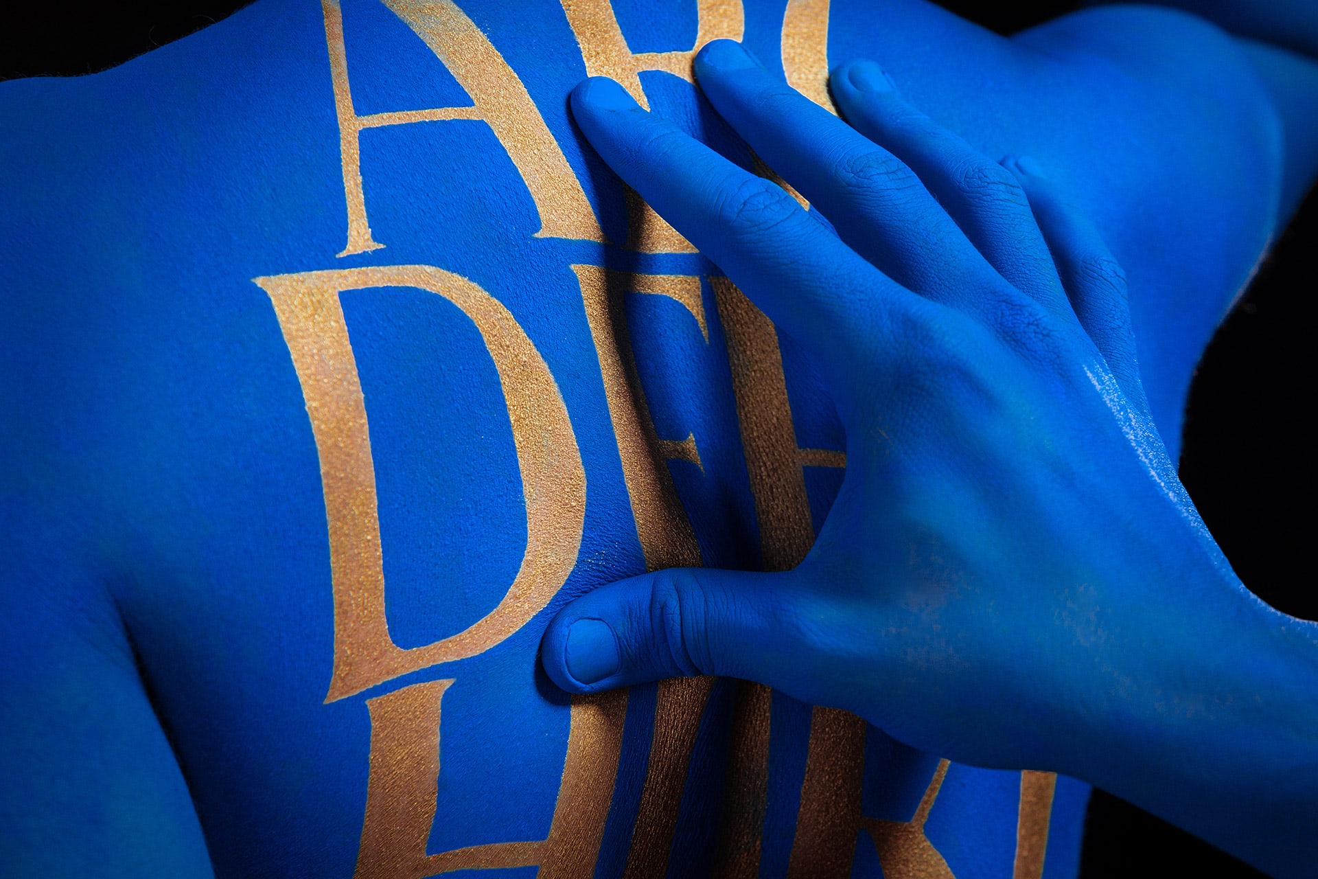 The elegant Ereganto Serif bodypainted on the skin of KOBU Agency's team members.