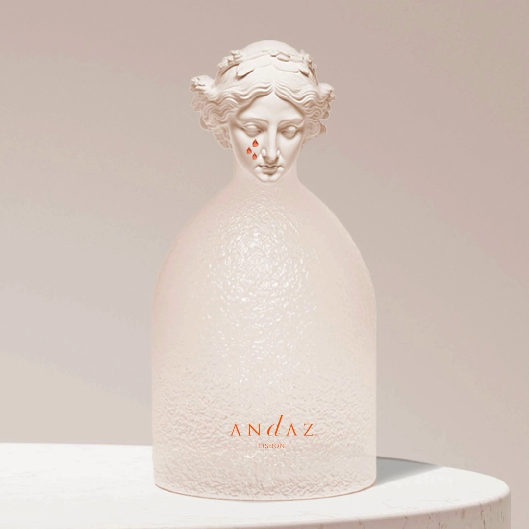 Minimalist white sculpture bottle with a classical female figure and Andaz Lisbon logo