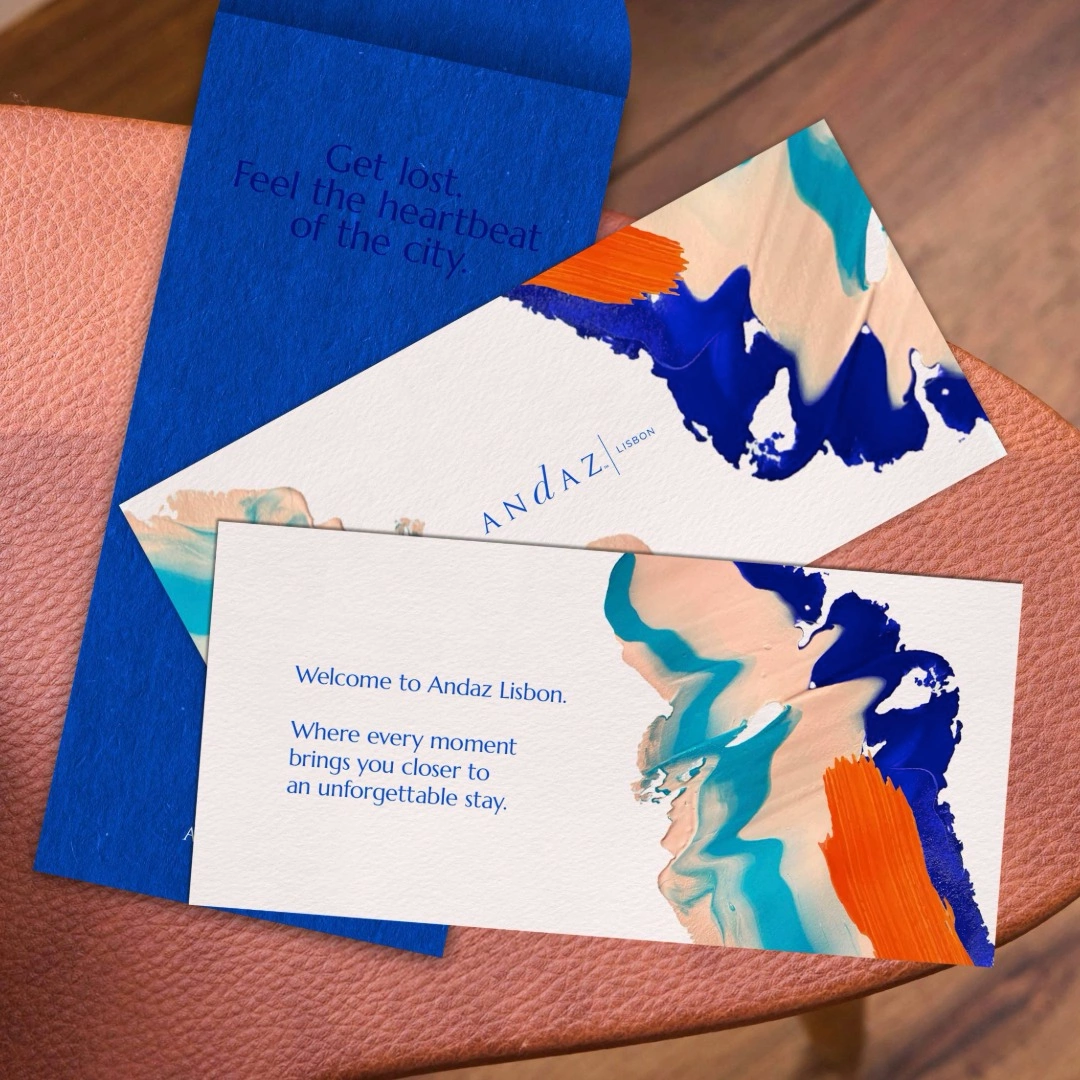 Andaz Lisbon welcome cards with artistic blue and orange brushstroke designs on a leather surface