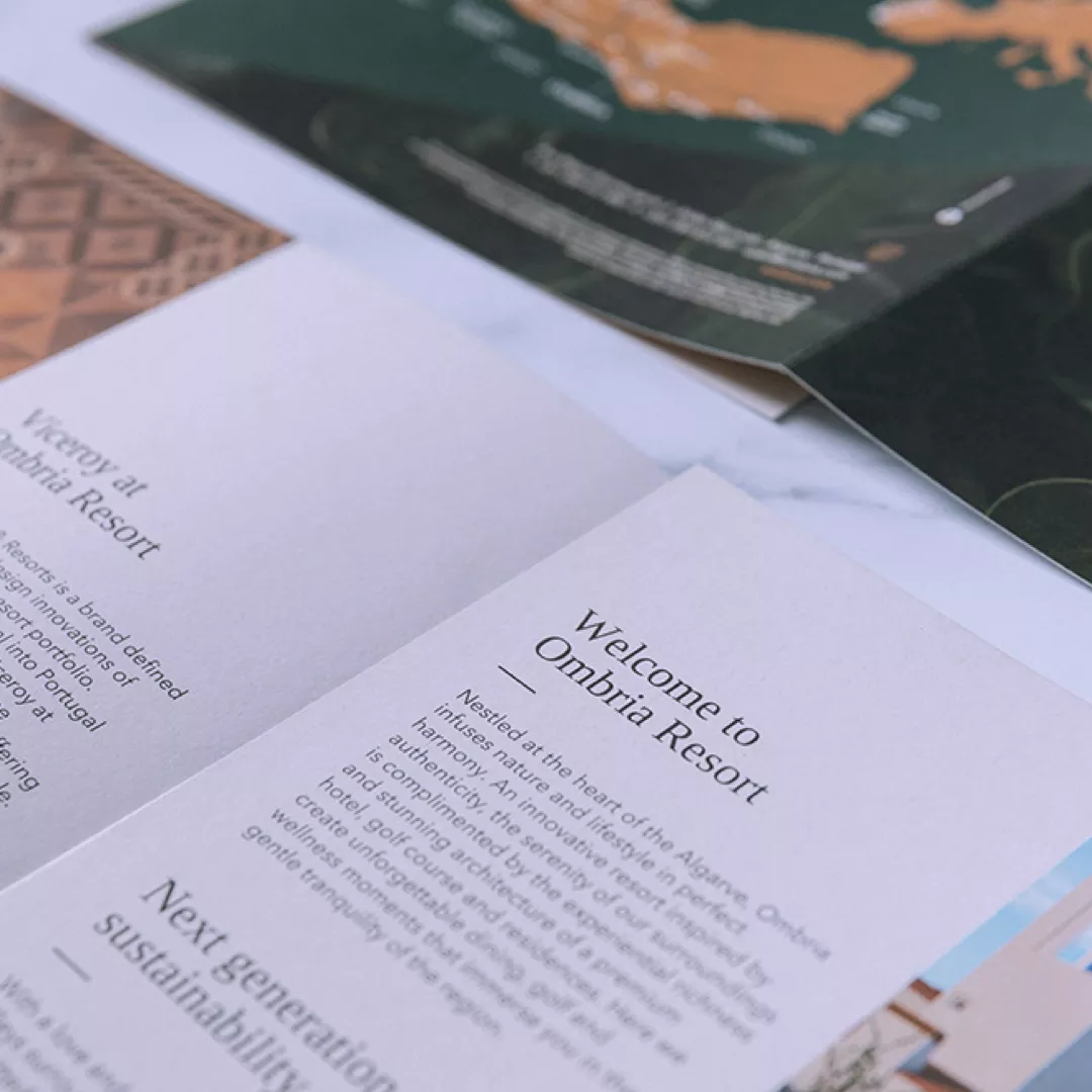 Close-up of Ombria brochure and map featuring text about sustainability and luxury living