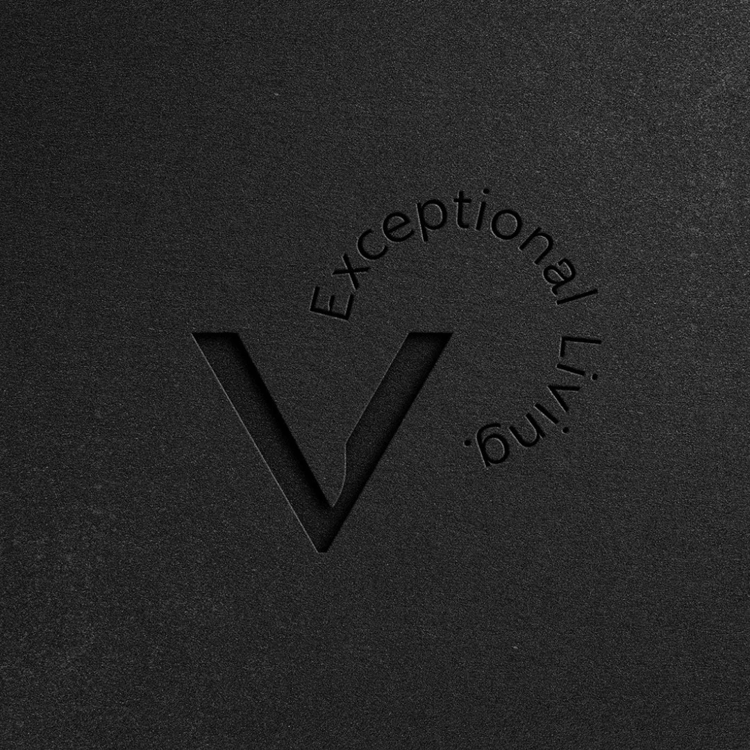 Embossed TheV Apartments logo with the text 'Exceptional Living' on a black textured background